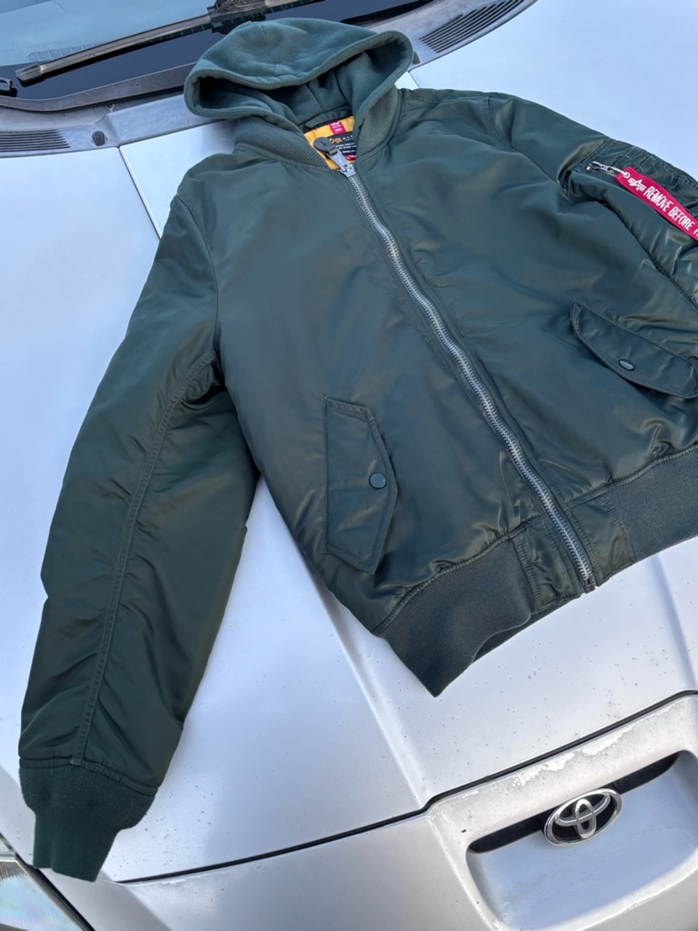 This is an Alpha Industries MA-1 bomber flight jacket with a detachable hood